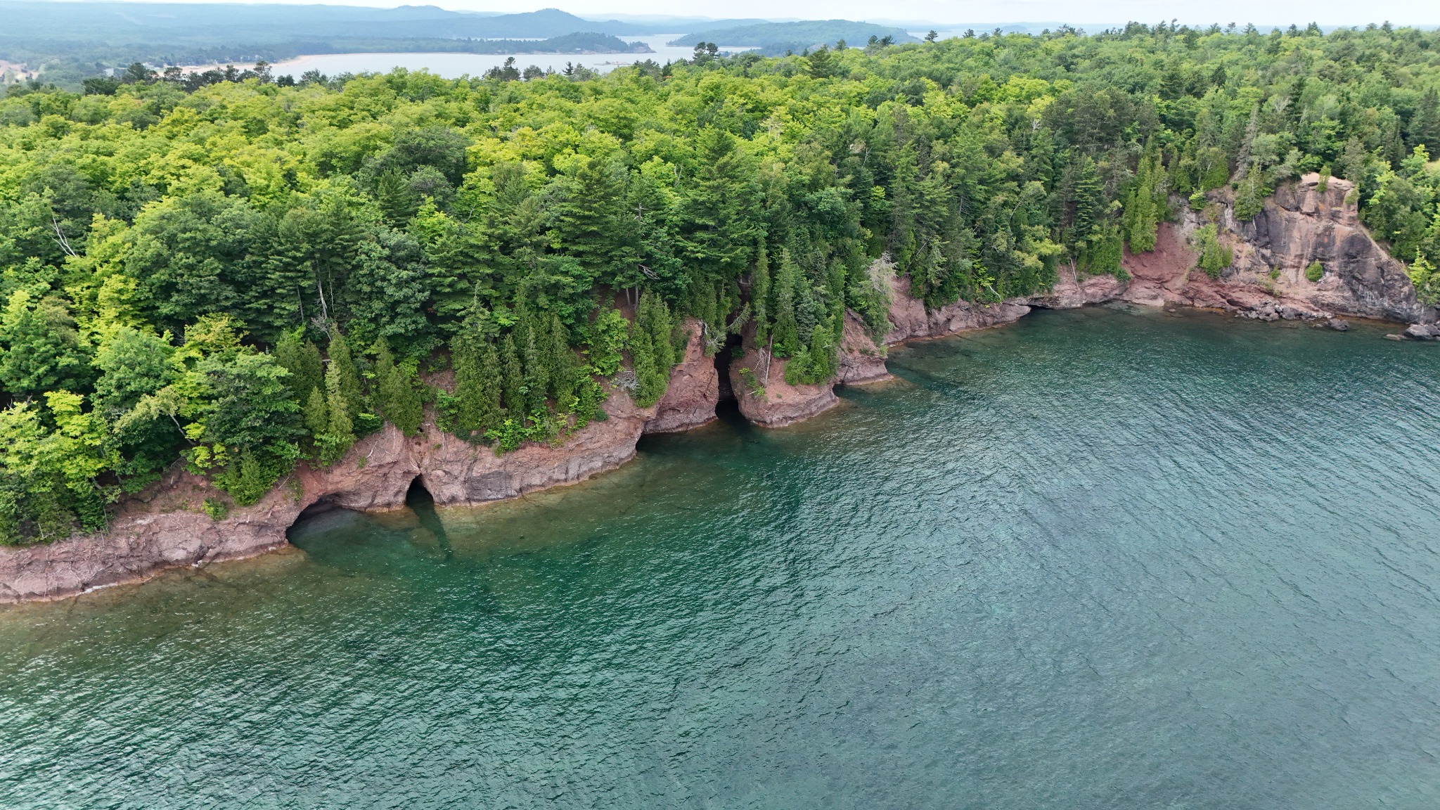 Aerial view of a rocky Lake Superior shoreline surrounded by forest